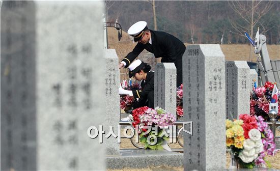 해군 장교가 현충원을 방문해 묘를 정리하고 있다. 