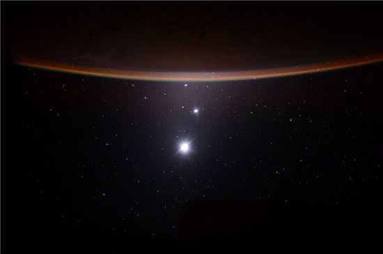 ▲지구를 배경으로 달(가장 큰 것), 금성(중간), 목성(작은 빛)이 빛을 발하고 있다.[사진제공=NASA/Scott Kelly]