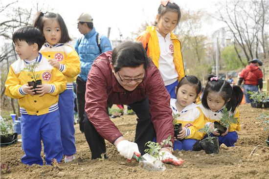 김기동 광진구청장이 자투리땅 개장식에서 꽃을 심고 있다.