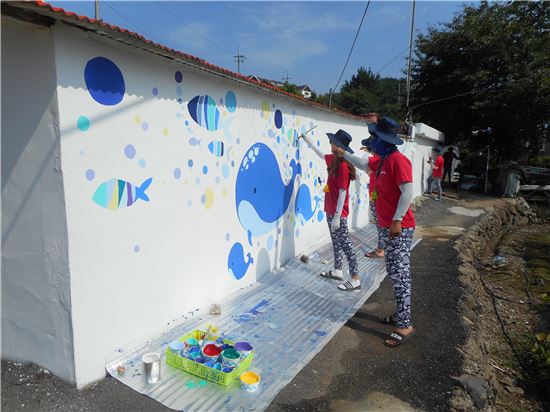 한밭대 학회연합회 임원과 재학생들이 충남 태안군 안면읍 황도리에서 바다 생물들을 주제로 한 벽화 봉사활동을 펼치고 있다.