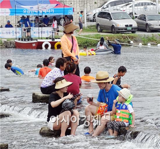 연일 30℃를 웃도는 찜통더위가 기승을 부리고 있는 가운데 31일 제8회 정남진 장흥 물축제가 열리고 장흥군 탐진강변에 전국에서 수많은 관광객들이 찾아왔다.  이날 장흥물축제장을 찾은 가족들이 시원한 탐진강에 발을 담그고  한여름 무더위를 식히고 있다. 

장흥물축제는 7월 31일부터 8월 6일까지 탐진강과 우드랜드 일원에서는 ‘물과 숲 - 休’의 주제로 제8회 정남진 장흥 물축제가 개최된다.
