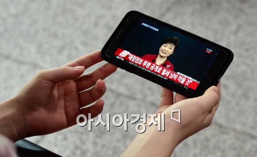 [포토]스마트폰으로 박근혜 대통령 대국민 담화 시청하는 시민