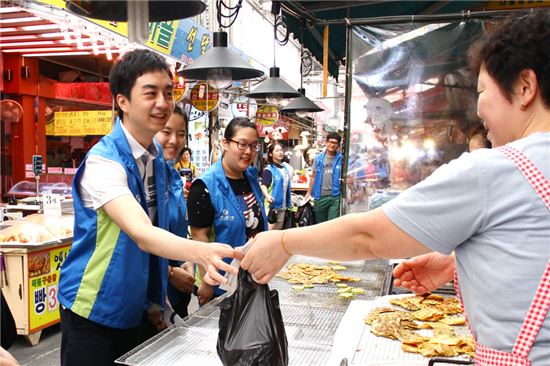 신한은행 고객봉사자들이 6일 서울 강서구에 위치한 송화전통시장에서 독거노인들을 위한 식료품을 구매하고 있는 모습. 