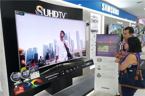 싱가포르 베스트 덴티 가전 매장의 이안시티점에서 고객들이 삼성전자 SUHD TV로 상영되고 있는 단편 영화를 감상하고 있다.