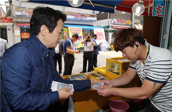 전통시장을 찾은 남경필 경기지사가 온누리상품권으로 물건값을 지불하고 있다.