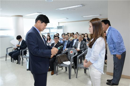 아름동 주민센터를 방문한 이춘희 시장이 5만번째 전입자 황나예씨에게 기념패를 수여하고 있다.