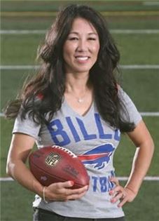 NFL의 여성 구단주인 킴 페굴라(46)씨가 버펄로 빌스 티셔츠를 입고 풋볼 공을 들고 있다. 사진제공=데모크랫 & 크로니클