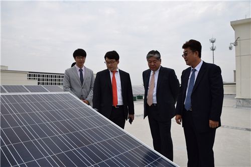 ▲OCI 이우현 사장(왼쪽에서 두 번째)이 중국 저장성 자싱시에 위치한 파트너사 CMAG 옥상에 설치된 태양광발전소 현장을 실사하고 있다.
