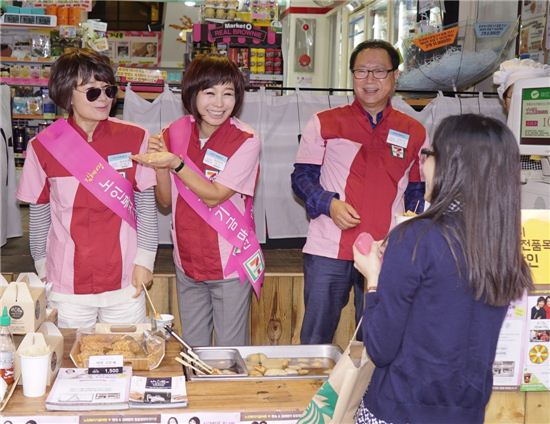 세븐일레븐 일일점장에 나선 방송인 김혜영(왼쪽 첫번째), 가수 현숙(왼쪽 두번째), 그리고 정승인 세븐일레븐 대표(왼쪽 세번째)가 매장을 찾은 고객에게 상품을 판매하고 있다.