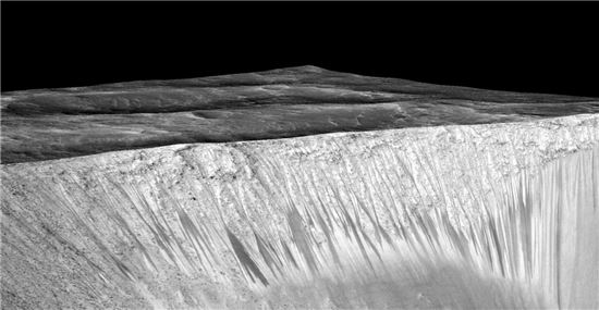 ▲어두운 경사면인 화성의 RSL에 소금물이 지금도 흐르고 있는 것으로 나타났다.[사진제공=NASA]