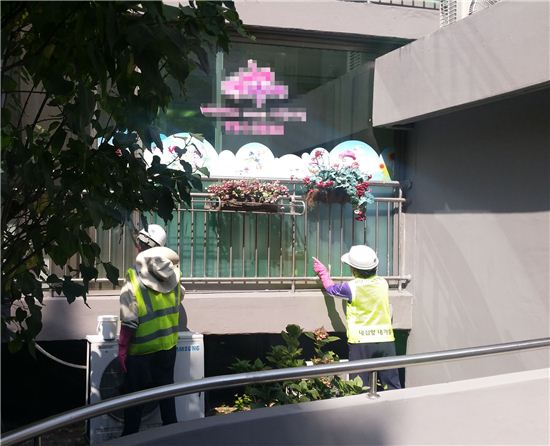 성남시청 공무원들이 주택침입 범죄 예방을 위해 베란다 등에 형광물질을 바르고 있다.