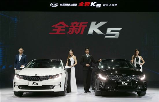 중국형 신형 K5를 배경으로 모델이 포즈를 취하고 있는 모습.
