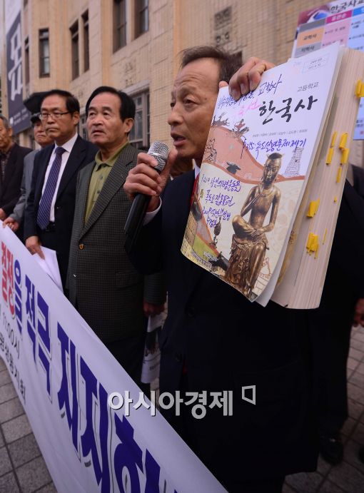 [포토]한국사교과서 들어보이는 서울중등교장평생동지회 회원