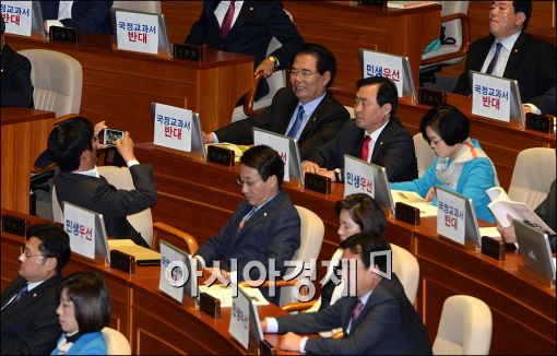  박근혜 대통령이 27일 2016년도 예산안 및 기금운용계획안에 대한 시정연설을 위해 국회를 찾은 가운데 새정치민주연합 의원들이 본회의장 모니터에 '국정교과서 반대', '민생우선'이라고 쓰여진 종이를 붙여놨다.