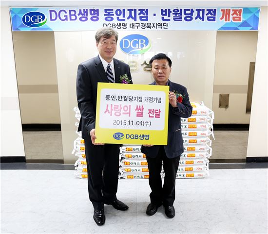 오익환 DGB생명 대표(왼쪽)가 지점 개소식 축하 화환을 대신해 기부 받은 쌀 600kg을 대구 중구청 관계자에게 전달하면서 기념촬영을 하고 있다.

