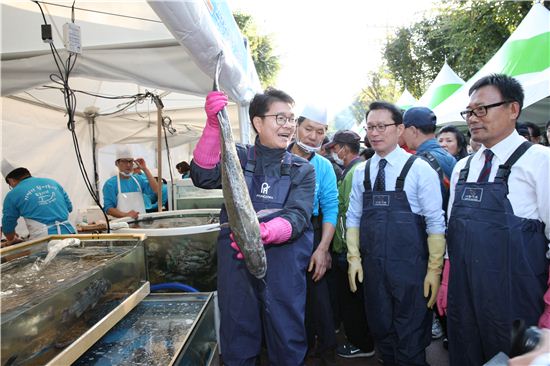 정원오 성동구청장이 지난달 28일 뚝도나루터에서 서해5도에서 잡아온 활어인 농어를 들어보이고 있다.