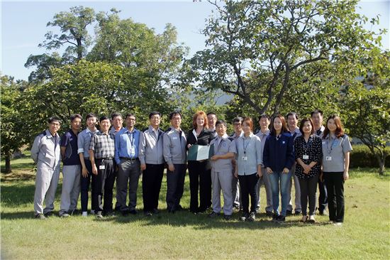 사진은 한국GM 임직원들과 GM 환경 담담 매니저가 함께 인증을 축하하는 모습. 왼쪽에서 일곱번 째 조연수 부사장, 오른쪽에서 아홉번 째 군산공장 김선홍 전무, 가운데 수잔 D 켈시 글로벌 생물다양성 프로그램 매니저
