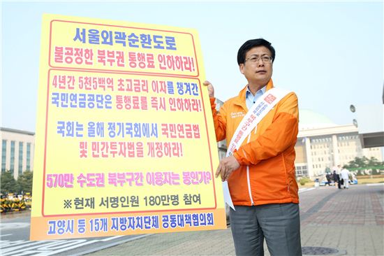 최성 고양시장이 국회의사당 앞에서 서울외곽순환도로 북부구간 통행료의 부당성을 지적하며 1인 시위를 하고 있다. 