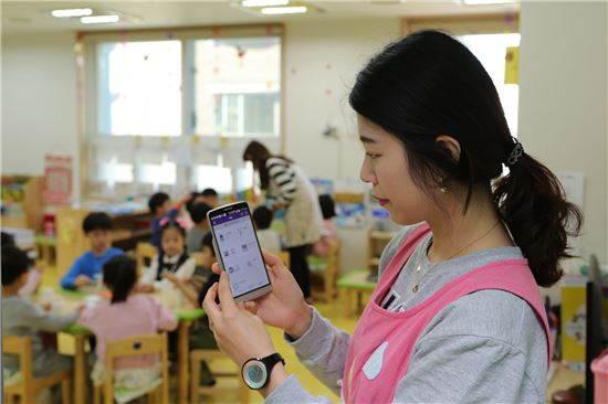 LG 유플러스는 서울 금천 구립 새롬어린이집에서 광기가 IoT앳홈(@home) 어린이집 설치를 완료하고 현판식을 가졌다고 18일 밝혔다. 사진은 서울 금천 구립 새롬어린이집에서 보육교사가 스마트폰으로 IoT서비스를 시연하고 있는 모습.(사진=LG유플러스)