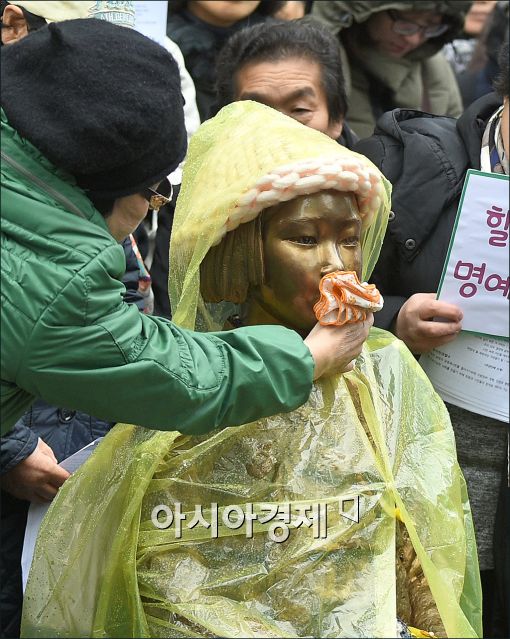 [포토]소녀상 빗물 닦아주는 시민