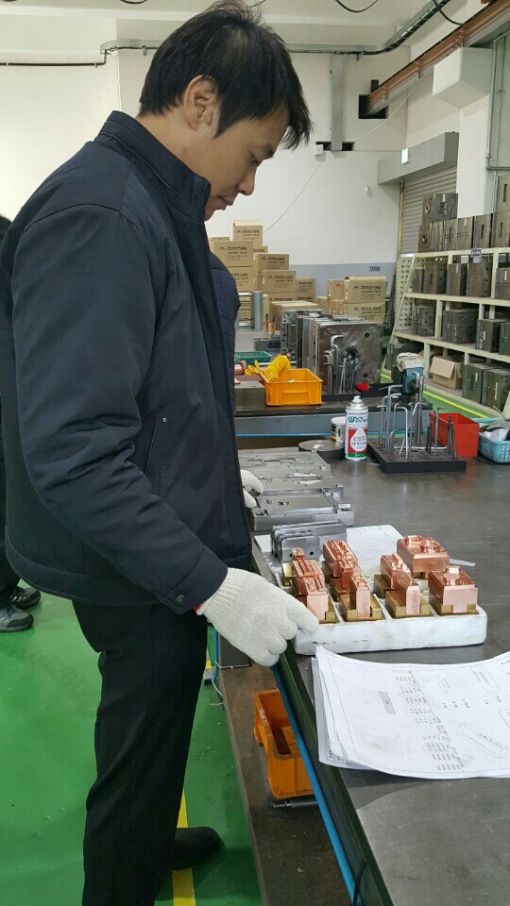 홍기수 리더스이엔지 대표가 휴대폰케이스 생산설비를 점검하고 있다.