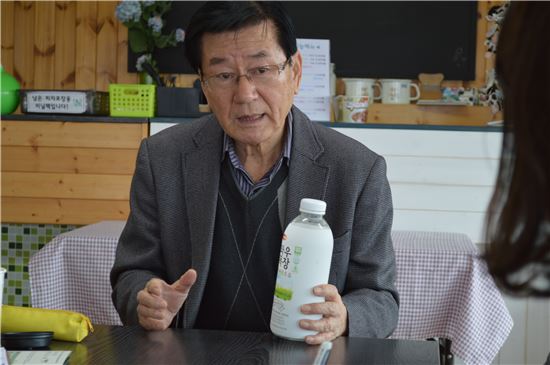 ▲위철연 와우목장 대표가 목장 내 생산시설에서 만든 자체 브랜드 우유를 들고 설명하고 있다.