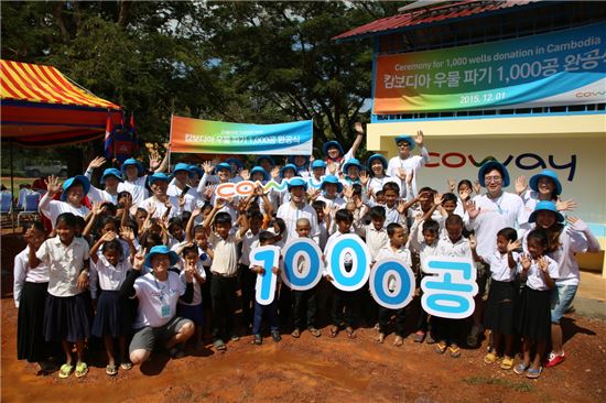 김동현 코웨이 대표이사(두 번째줄 오른쪽 두 번째)와 임직원들이 ‘캄보디아 우물 1,000공 완공식’ 행사 후 깜폿지역 주민들과 함께 기념 촬영을 하고 있다.