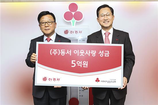 윤세철 동서 부사장(왼쪽)이 김주현 사회복지공동모금회 사무총장(오른쪽)에게 이웃돕기 성금 5억원을 전달하고 있다.
