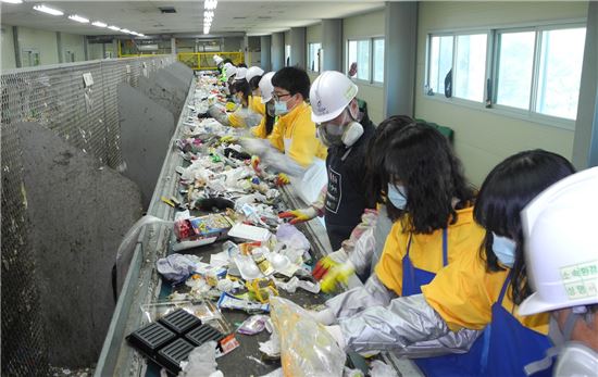 <김형원 센터장이 고안해 특허를 받은 재활용쓰레기 선별시스템에서 학생들이 쓰레기 선별을 체험하고 있다.>
