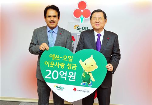 ▲나세르 알 마하셔 에쓰오일 대표가 28일 서울 중구 사회복지공동모금회 대회의실에서 허동수 사회복지공동모금회장에게 이웃돕기 성금 20억원을 기탁하고 있다. 
