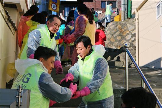 김선덕 HUG 사장(앞줄 오른쪽)을 포함한 임직원과 대학생 봉사단 40여명이 연탄 나르기 봉사활동을 실시하고 있다.(사진= HUG)
