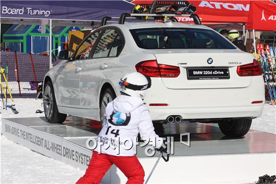 9일 강원도 홍천에서 열린 'BMW x드라이브 컵 코리아 2016' 스키대회에 참가한 어린이가 대회 개최사 BMW가 전시한 차량을 바라보고 있다.