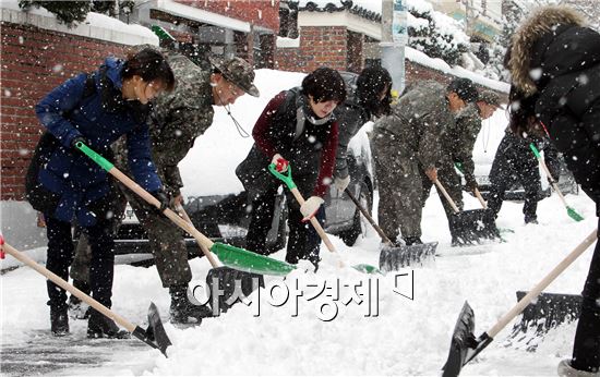 광주·전남 지역에 올 들어 가장 많은 량의 눈이 내린 가운데 19일 광주 북구 용봉동 주민센터(동장 김병호) 직원들이 관내 이면도로에서 제설장비를 이용해 도로에 쌓인 눈을 치우고 있다.  사진제공=광주시 북구