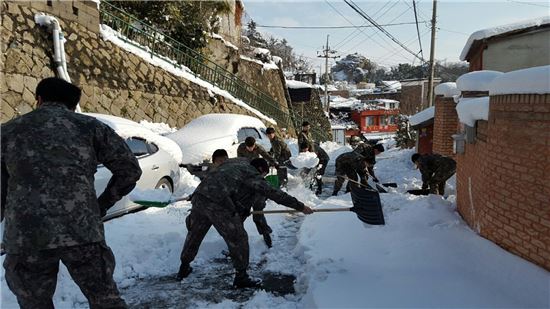 <목포 인근의 육군 및 해군 부대 장병들이 목포시의 제설작업에 동참해 구슬땀을 흘리고 있다.>