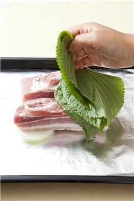 4. 돼지고기에 깻잎을 2~3장씩 겹쳐 덮어서 오븐 팬에 양파를 깔고 올려 220도에서 30분 정도 익힌다.