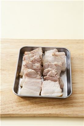 6. 돼지고기는 한 김 식으면 먹기 좋은 크기로 썰고 묵은지와 무말랭이 무침을 곁들이고 풋고추, 홍고추, 마늘, 쌈장을 곁들인다.
