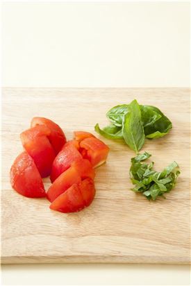 2. 껍질을 벗긴 토마토는 먹기 좋은 크기로 썰고 바질은 굵게 채 썰고, 오이는 길이로 반달 모양으로 썬다.
