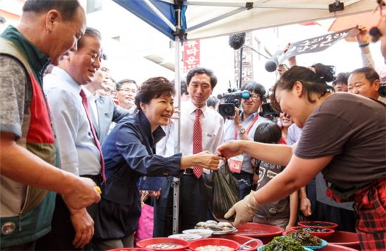 박근혜 대통령이 지난해 7월 15일 울산 태화종합시장을 방문해 해산물을 구매하고 있다.(사진제공 : 청와대)