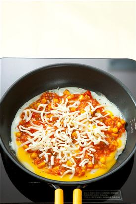 4. 달걀을 약한 불에서 익히다가 2의 토마토소스를 골고루 올리고 피자 치즈를 올려 불을 뚜껑을 덮은 상태로 그대로 두어 치즈를 녹인다.
