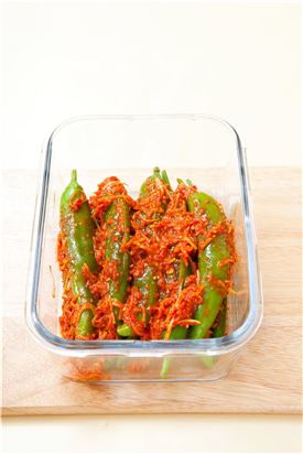 6. 김치통에 고추소박이를 차곡차곡 눌러 담고 양념에 잘 잠기도록 한다.