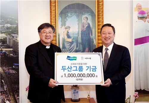 ▲박용만 두산그룹 회장(오른쪽)이 24일 서울 명동성당에서 조규만 재단법인 '바보의 나눔' 이사장에게 성금 10억 원을 전달하고 있다.
