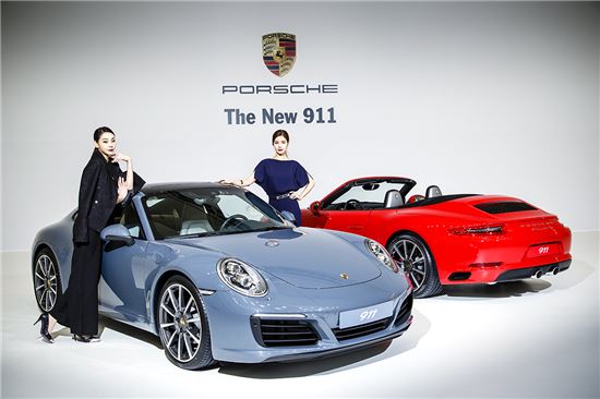 포르쉐 홍보모델들이 신형 911 카레라(왼쪽)와 911 카레라S(오른쪽) 출시를 기념해 차 옆에서 기념촬영을 하고 있다.