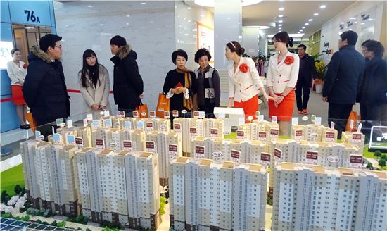 <구 상록회관 2층에 마련된 '우산동 쌍용예가' 견본주택을 찾은 수요자들이 아파트단지 모형을 살펴보고 있다.>