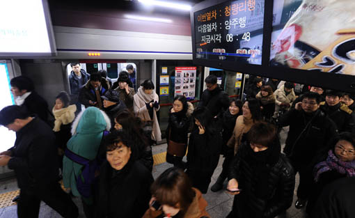 승객들이 지하철에서 내려 목적지로 향하고 있다.