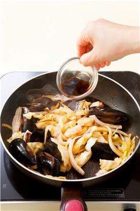 5. 프라이팬에 고추기름을 두르고 양파와 양배추를 넣어 2분 정도 볶다가 오징어, 홍합, 새우를 넣어  5분 정도 볶은 다음 소스를 넣는다.
