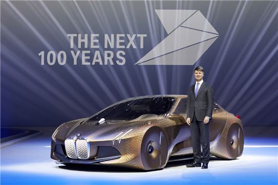 하랄드 크루거 BMW그룹 회장이 '비전 비히클 넥스트 100' 옆에서 기념 촬영을 하고 있다.
