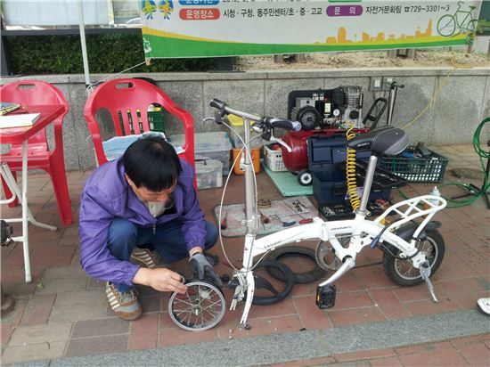 성남시가 올해도 찾아가는 이동식 자전거정비소를 운영한다. 자전거 전문가가 고장 난 자전거를 고치고 있다. 