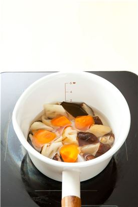 3. 냄비에 다시마와 연근, 표고버섯, 당근을 넣고 물 1컵을 넣어 끓인다.
