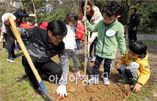 식목일을 보름 여일 앞둔 21일 광주 북구 두암동 제1근린공원에서 열린 제71회 식목일 나무심기 행사에서 북구청 공원녹지과 직원들과 고운어린이집 원생들이 왕벚나무를 심고 있다. 북구는 이날 왕벚나무 15주와 편백 나무 120주를 근린공원에 인근에 심었다. 사진제공=광주시 북구