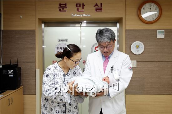 전남대학교병원에서 일곱 번째의 제왕절개수술을 통해 출산한 산모(왼쪽)와 수술을 집도한 김윤하 교수(오른쪽)가 건강하게 태어난 신생아를 기쁜 마음으로 바라보고 있다.